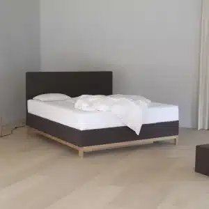 AKVA Carla vannseng i lyst nordisk soverom med eikegulv og tekstilramme